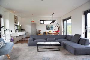ein Wohnzimmer mit einem blauen Sofa und einem Tisch in der Unterkunft Casa Bonbon in Jeju-do