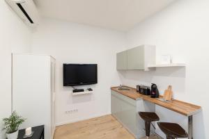 a kitchen with a desk and a tv on the wall at Madach Apartment in Budapest