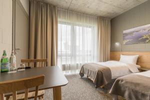 a hotel room with two beds and a table at Air Hotel in Karmėlava