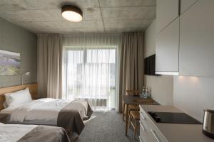 a hotel room with two beds and a kitchen at Air Hotel in Karmėlava