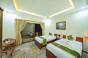 a hotel room with two beds and a balcony at Herbal Tea Homestay in Hoi An +63 photos