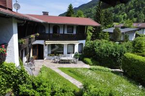 ein Haus mit einer Terrasse und einem Garten in der Unterkunft Hotel Garni Liberia in Oberstdorf
