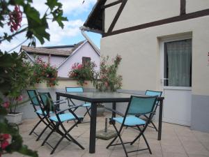 una mesa y sillas en el patio de una casa en GITE DU FLORIMONT CENTRE ALSACE route des vins, en Ingersheim