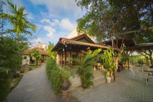 a house with a lot of plants in front of it at Herbal Tea Homestay in Hoi An