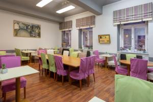 布拉格的住宿－布拉格市中心廣場酒店，一间带桌子和紫色椅子的用餐室