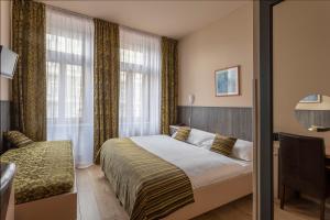 a bedroom with a bed and a desk and a window at Hotel Superior Prague in Prague