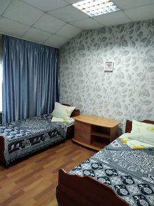 a room with two beds and a table in it at Hotel Kuibyshevskaya in Novokuznetsk
