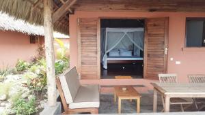 a room with a bed and a table and chairs at LE TRANSAT in Ambatoloaka