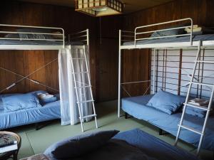 a room with two bunk beds and a couch at Guesthouse ＆ Beach Cafe Fuego in Hyuga