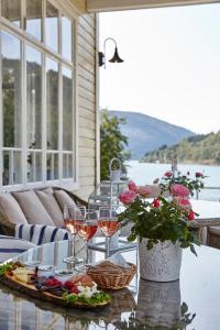 einen Tisch mit Gläsern Wein und einen Teller mit Essen in der Unterkunft Visnes Hotel Stryn in Stryn