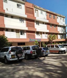 eine Gruppe von Autos, die vor einem Gebäude geparkt sind in der Unterkunft Bomen Hotel in Isiolo