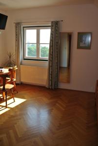 a living room with a wooden floor and a window at Weingut Primus Südsteiermark in Spielfeld