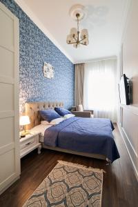 LUX APARTAMENT на Левицького في إلفيف: غرفة نوم بسرير وجدار ازرق