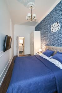 a blue bedroom with a large bed with a blue wall at LUX APARTAMENT на Левицького in Lviv