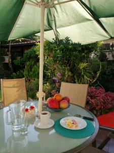a table with a plate of fruit and an umbrella at Granados in Asunción