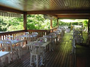 una fila de mesas y sillas en una terraza de madera en Au Faisan Doré en Neuville-sur-Ain