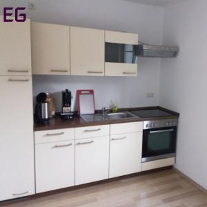 a kitchen with white cabinets and a sink at Apartment am Golfplatz in Brochthausen