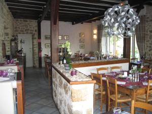 a restaurant with a bar with tables and chairs at Au Faisan Doré in Neuville-sur-Ain +16 photos