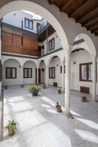 a large courtyard with columns and plants in a building at Bustos Tavera in Seville