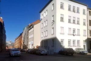 un edificio bianco con macchine parcheggiate di fronte di Ferienwohnung Geratal II a Erfurt