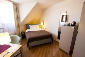 een slaapkamer met een bed en een stoel in een kamer bij Design Hotel Zollamt in Kaiserslautern