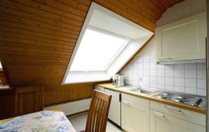 a kitchen with a window and a sink and a table at Gaestehaus-Achtern-Diek-Wohnung-11 in Süderhöft