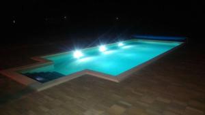 a swimming pool with lights in the dark at Bungalows Rizvan City in Brušane