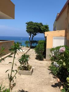 a pathway leading to a house with the ocean in the background at LA MESONETTE A DUE PASSI DAL MARE in Tropea