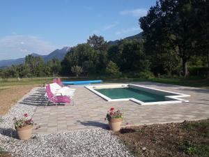 a patio with a pool and a chair and flowers at Holiday Home Rizvan City in Brušane
