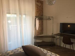 a living room with a tv and a bed and a table at Mazzini 33 in Lainate