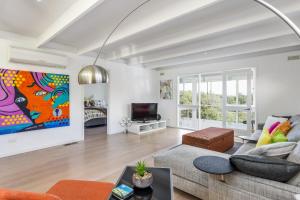 a living room with a couch and a tv at At Agnes Ave: coastal views in Blairgowrie