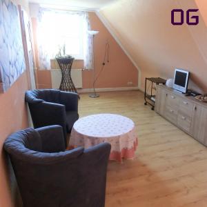 ein Wohnzimmer mit einem Tisch, Stühlen und einem Sofa in der Unterkunft Apartment am Golfplatz in Brochthausen