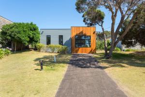 a wooden house sitting on top of a yard at At Agnes Ave: coastal views in Blairgowrie