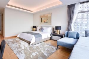 a hotel room with a bed and a chair at The Clouds Apartment in Shenzhen