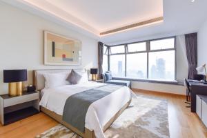 a white bedroom with a bed and a desk and window at The Clouds Apartment in Shenzhen