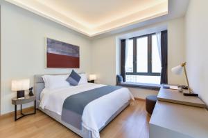 a bedroom with a large bed and a window at The Clouds Apartment in Shenzhen