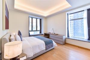 a bedroom with a large bed and two windows at The Clouds Apartment in Shenzhen