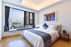 a bedroom with a large bed and a large window at The Clouds Apartment in Shenzhen