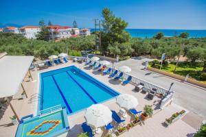 - une vue sur la piscine bordée de chaises et de parasols dans l'établissement Kozanos Hotel & Suites, à Amoudi