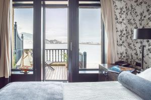 Schlafzimmer mit einem Bett und Blick auf einen Balkon in der Unterkunft Ercilla Embarcadero Hotel in Getxo