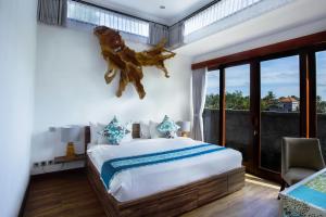 a bedroom with a large bed and a window at The Samara Villas & Restaurant in Ubud