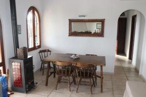 uma sala de jantar com uma mesa, cadeiras e um espelho em Chia Aloe & Cactus em Chia