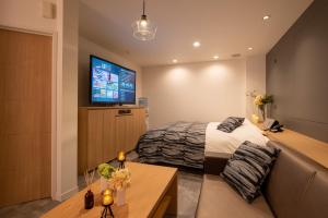 a bedroom with a bed and a flat screen tv at Hotel Waraku Shibukawa in Shibukawa
