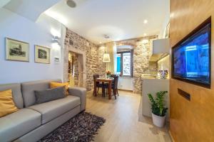sala de estar con sofá y TV y cocina en Golden Palace, en Split