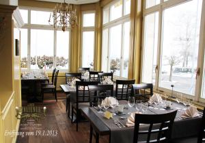 a dining room with tables and chairs and windows at Rigiblick am See in Buochs