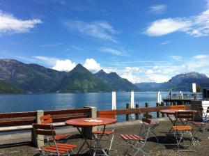 a patio with tables and chairs next to a body of water at Rigiblick am See in Buochs