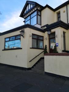 a large white house with glass windows and stairs at East Mount House in Barrow in Furness