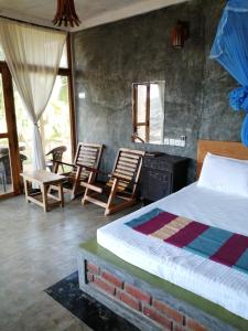 1 dormitorio con 1 cama, 2 sillas y chimenea en Sigiri Lake Paradise en Sigiriya