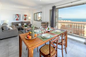een eetkamer met een tafel en uitzicht op de oceaan bij Apartamento Castello Playa in Can Picafort