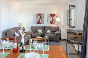 een woonkamer met een bank en een tafel met wijnglazen bij Apartamento Castello Playa in Can Picafort +14 foto's